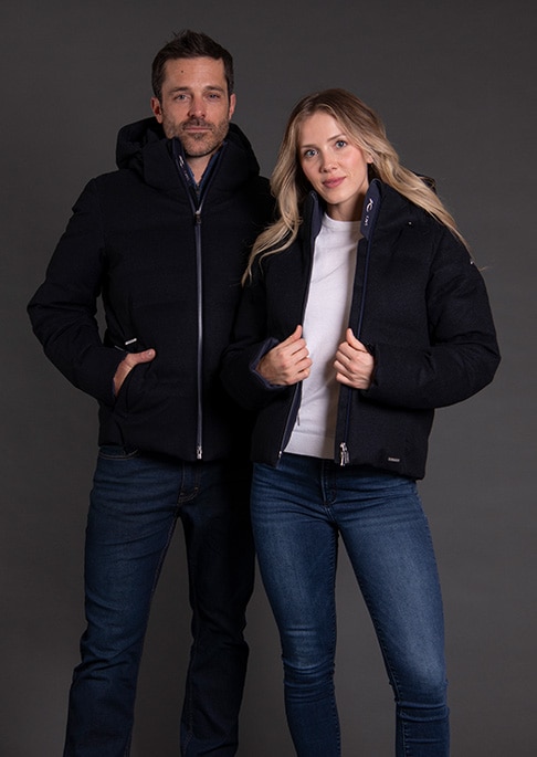 Models posing against dark studio background wearing luxury ski jackets.