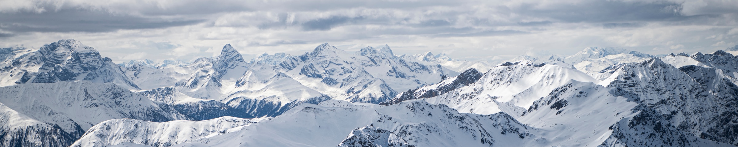 A snow-covered mountain range against a blue sky.