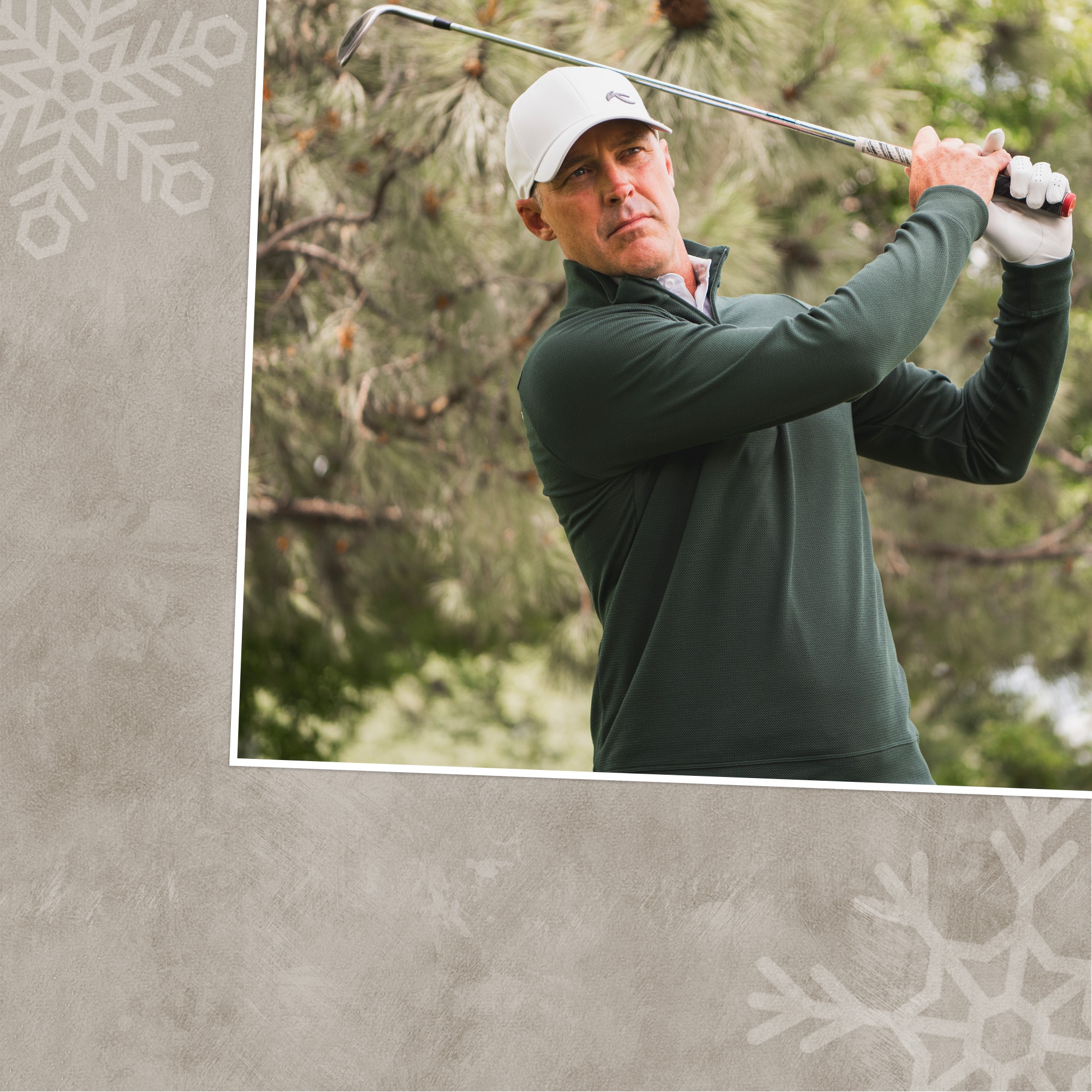 Golfer finishing his swing wearing KJUS half-zip in green with a white hat.