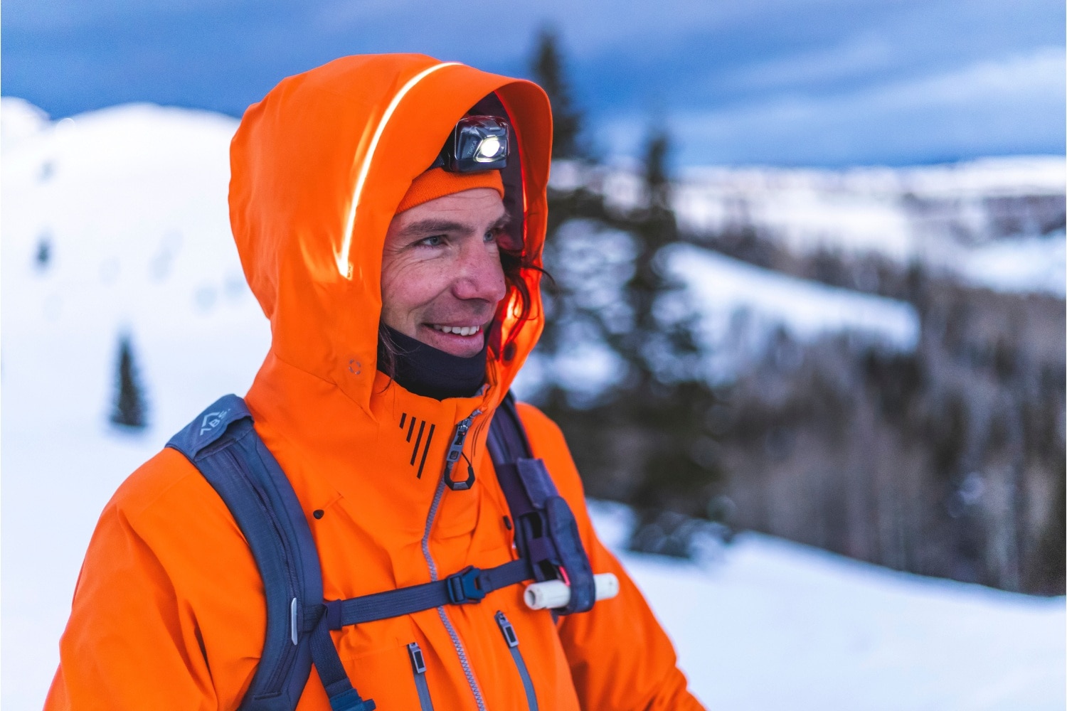 A man wearing an orange KJUS jacket.